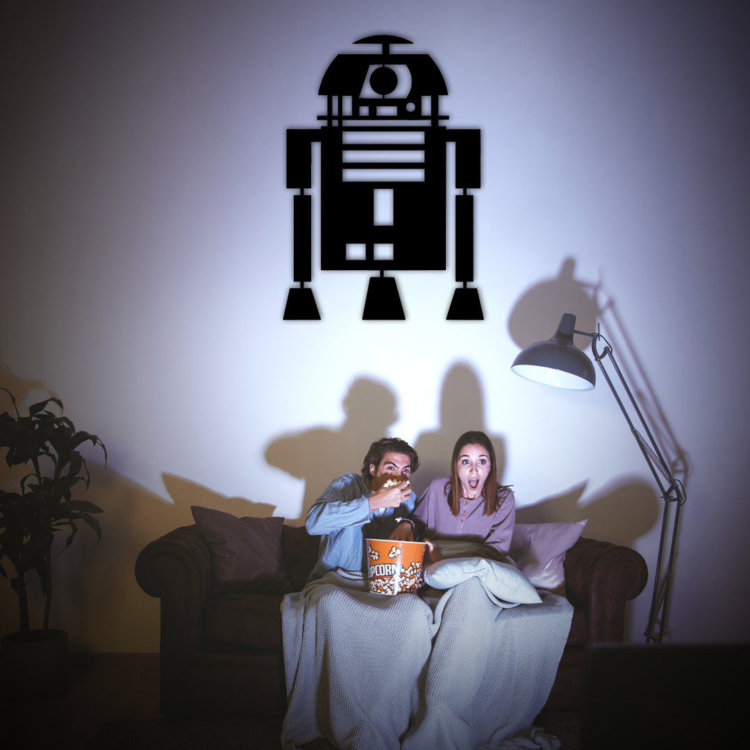 Installation sur un mur d'une décoration murale en métal finition noire, modèle R2D2